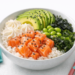 Poke bowl con salmone, avocado, edamame, alghe e riso, perfetto per un pasto gourmet e salutare.