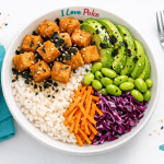 Poke bowl with crispy tofu, avocado, edamame, white rice, carrots, and purple cabbage, ideal for a healthy and tasty meal. Perfect for those looking for a dish rich in flavors and nutrients.