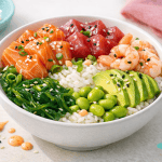Poke bowl with salmon, tuna, shrimp, avocado, edamame and rice, perfect for a fresh and healthy meal. Ideal for lovers of Hawaiian cuisine and raw fish dishes.
